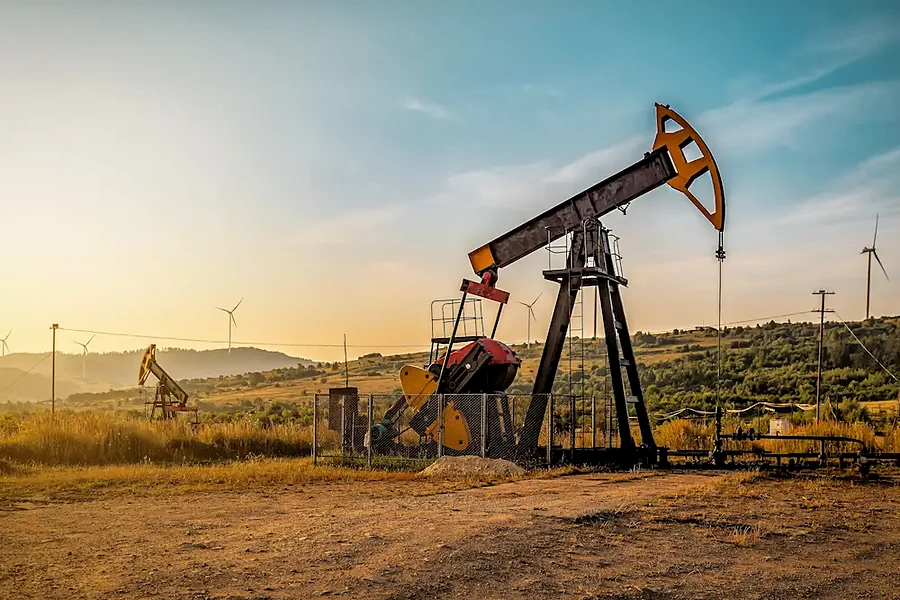 Bomba de haste em campo de extração de petróleo ao entardecer